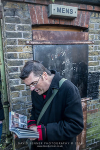 Paul Talling reading Derelict London outside an abandoned public toilet in Poplar Recreation Ground off East India Dock Road