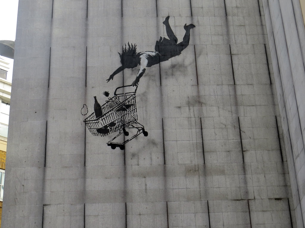 Shop til you drop Banksy Streetart showing a woman being dragged by a shopping trolley. On Bruton Lane on River Tyburn walk through Mayfair