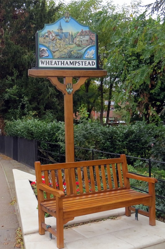 Wheathampstead High Street sign and bench beside the Lea