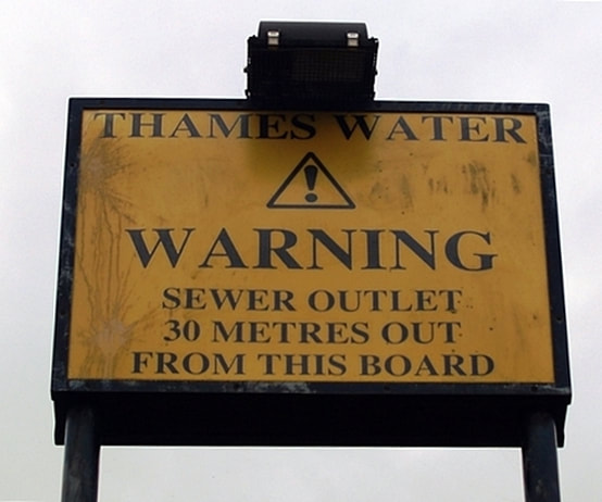 Earls Sluice - sewage outlet warning sign on the Thames foreshore at St Georges Stairs on the Thames at Rotherhithe. 