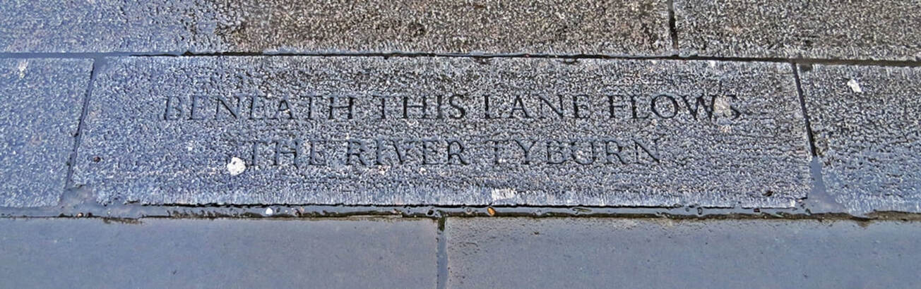 Marker on pavement in Marylebone Lane station 'Beneath this lane flows the River Tyburn' 